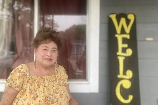 Ms. Vela sitting on her porch